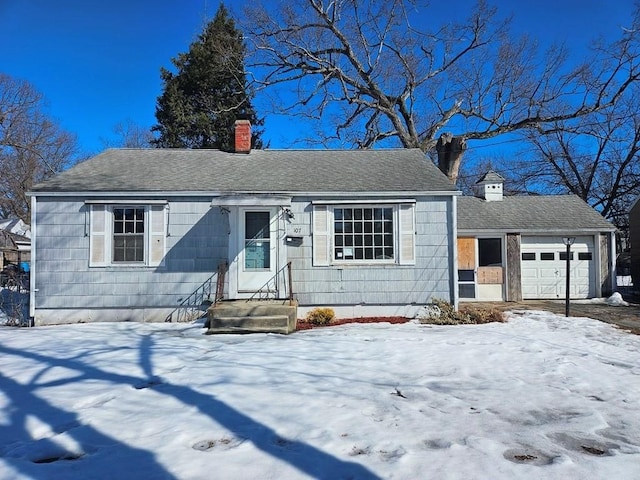 view of front of home featuring roof with shingles, a chimney, and an attached garage