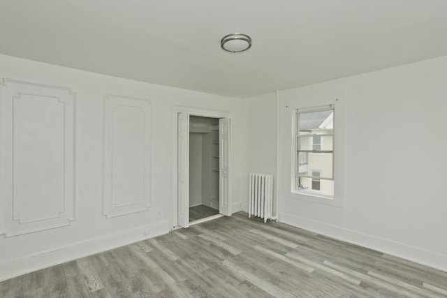 74 Everett St, Springfield, MA 01104 - unfurnished bedroom featuring radiator, baseboards, a closet, and wood finished floors