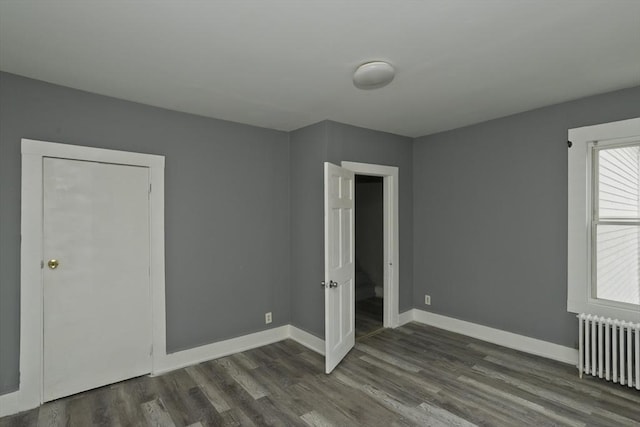 74 Everett St, Springfield, MA 01104 - unfurnished bedroom with radiator heating unit, baseboards, and dark wood-style flooring