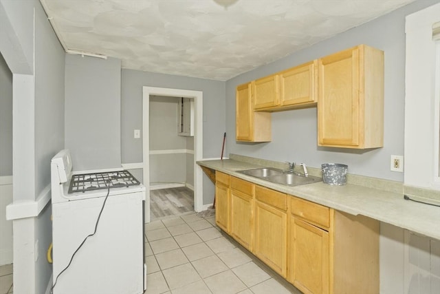 74 Everett St, Springfield, MA 01104 - kitchen featuring light brown cabinetry, a sink, light countertops, washer / dryer, and light tile patterned flooring