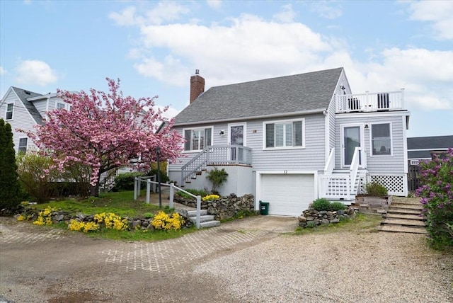 12 14th St, Newbury, MA 01951 - view of front facade featuring stairs, dirt driveway, a balcony, a chimney, and a garage