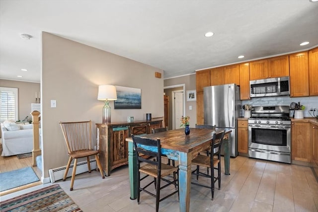 12 14th St, Newbury, MA 01951 - kitchen with stainless steel appliances, a baseboard radiator, brown cabinetry, light wood finished floors, and tasteful backsplash