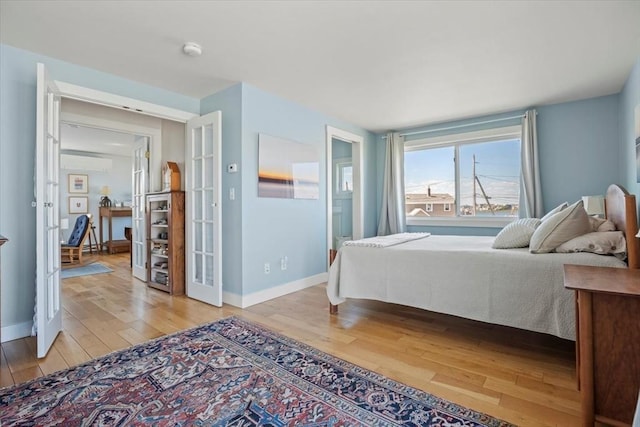 12 14th St, Newbury, MA 01951 - bedroom with light wood-type flooring, baseboards, french doors, and an AC wall unit