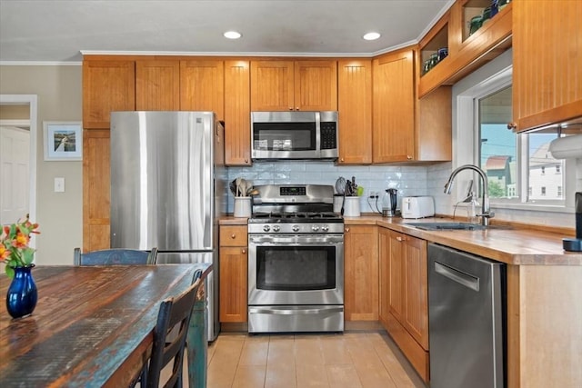 12 14th St, Newbury, MA 01951 - kitchen with stainless steel appliances, decorative backsplash, a sink, crown molding, and recessed lighting