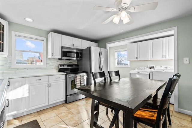 kitchen with white cabinets, tasteful backsplash, independent washer and dryer, and appliances with stainless steel finishes