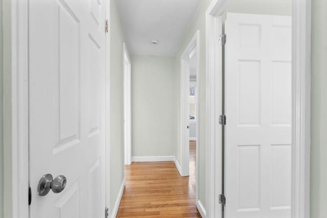 hallway with baseboards and light wood-style floors