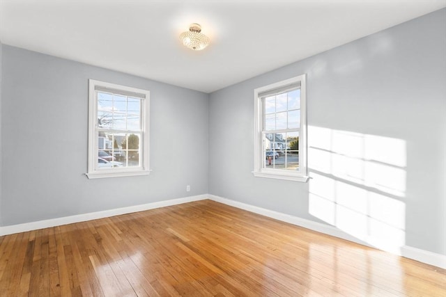 empty room with baseboards and hardwood / wood-style floors