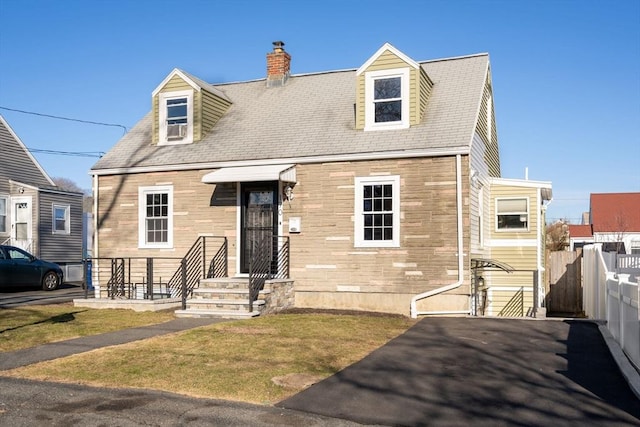 new england style home with fence and stone siding