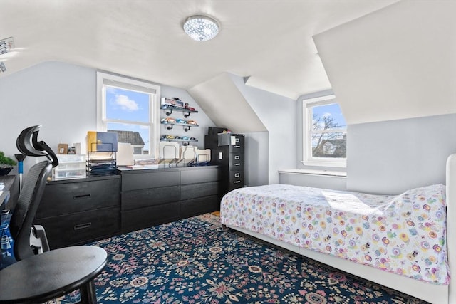 bedroom featuring multiple windows and lofted ceiling