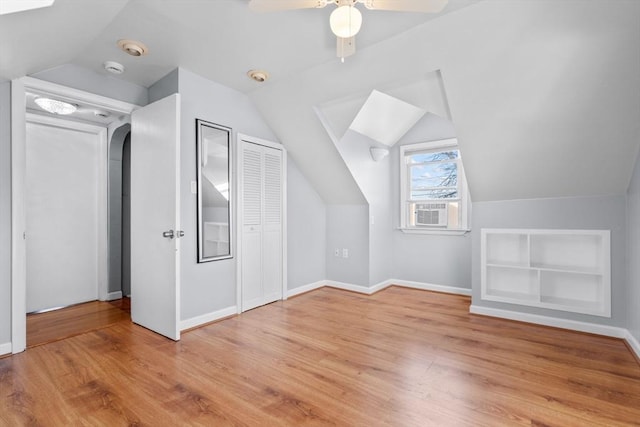 bonus room with ceiling fan, baseboards, lofted ceiling, cooling unit, and wood finished floors