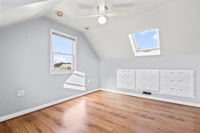 additional living space featuring vaulted ceiling, wood finished floors, baseboards, and ceiling fan