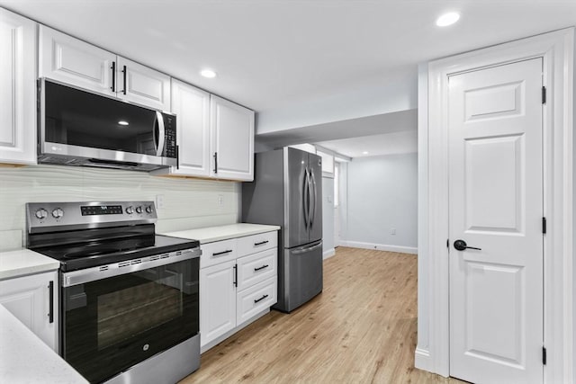 kitchen with tasteful backsplash, white cabinets, stainless steel appliances, and light countertops