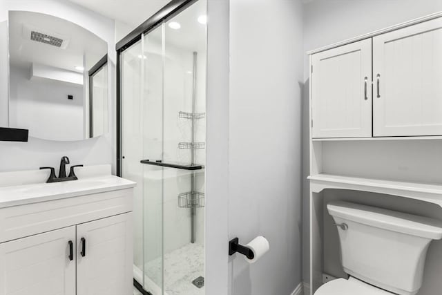 bathroom with vanity, toilet, visible vents, and a stall shower