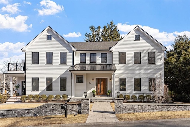 view of front of house featuring metal roof, a balcony, and a standing seam roof