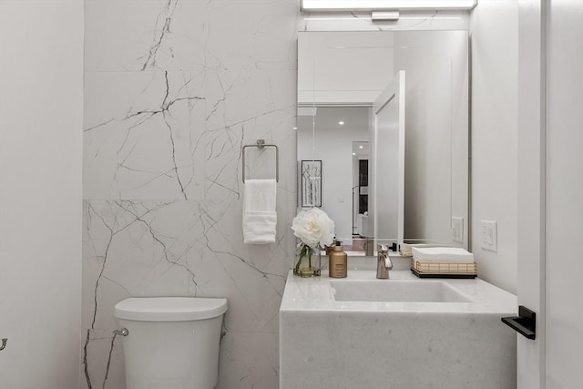 bathroom featuring tile walls, toilet, and vanity