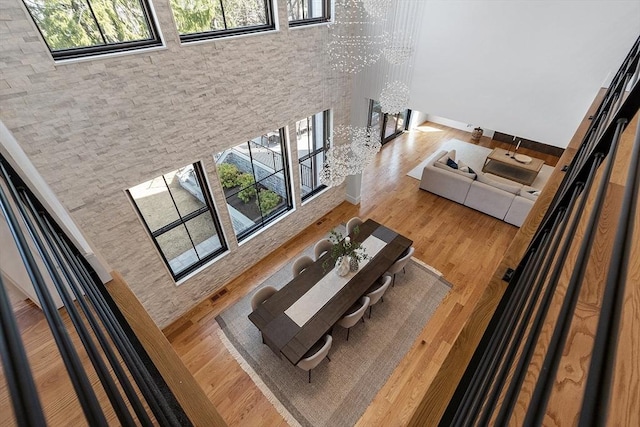 living room with a healthy amount of sunlight, wood finished floors, a high ceiling, and a chandelier