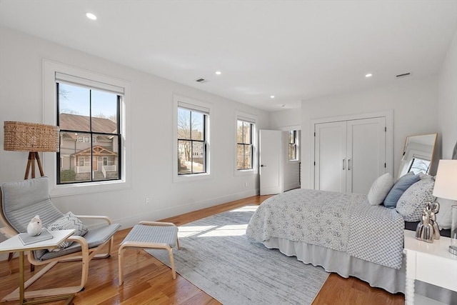 bedroom featuring visible vents, recessed lighting, a closet, light wood finished floors, and baseboards