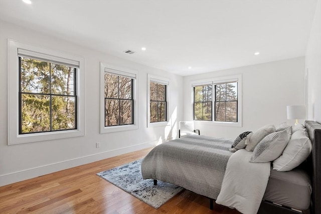 bedroom with light wood-type flooring, visible vents, baseboards, and recessed lighting