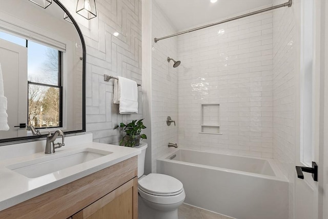 bathroom featuring toilet, vanity, and shower / tub combination