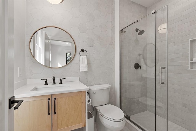 bathroom featuring toilet, a stall shower, and vanity