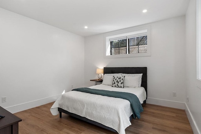 bedroom with recessed lighting, wood finished floors, and baseboards