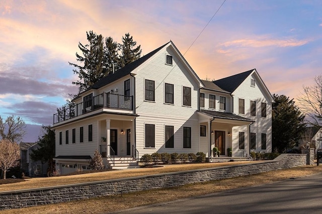 traditional home featuring metal roof, a balcony, and a standing seam roof