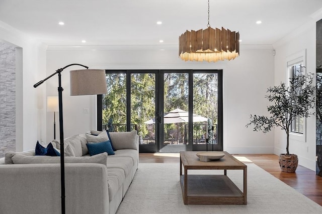 living area with recessed lighting, wood finished floors, baseboards, and ornamental molding