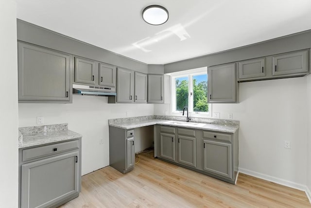 78 Saratoga Ave, Chicopee, MA 01013 - kitchen featuring under cabinet range hood, gray cabinetry, and light wood finished floors