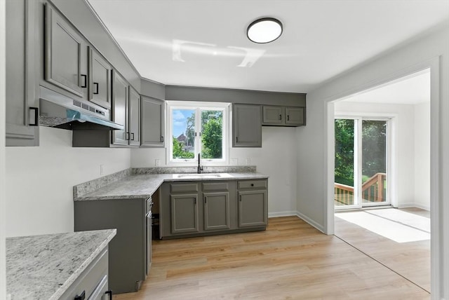 78 Saratoga Ave, Chicopee, MA 01013 - kitchen featuring under cabinet range hood, healthy amount of natural light, gray cabinets, and light wood-style flooring