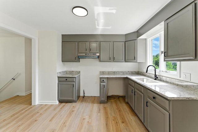 78 Saratoga Ave, Chicopee, MA 01013 - kitchen featuring gray cabinets, light wood finished floors, light stone counters, and under cabinet range hood