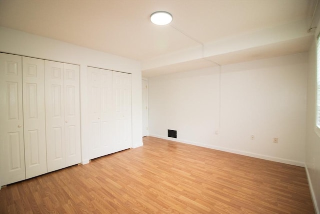 369 Aiken Ave Unit 15, Lowell, MA 01850 - unfurnished bedroom with light wood-style floors, two closets, and baseboards