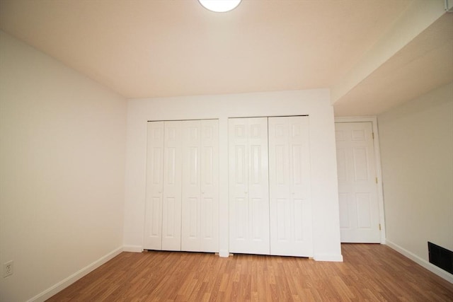 369 Aiken Ave Unit 15, Lowell, MA 01850 - unfurnished bedroom featuring light wood-type flooring, baseboards, and multiple closets