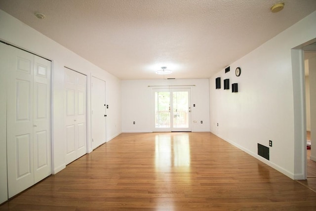 369 Aiken Ave Unit 15, Lowell, MA 01850 - unfurnished living room featuring light wood-style floors, baseboards, and a textured ceiling