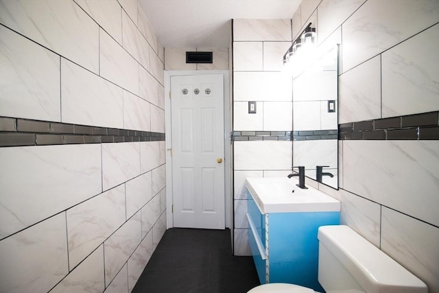 369 Aiken Ave Unit 15, Lowell, MA 01850 - bathroom featuring tile walls, toilet, vanity, and tile patterned flooring