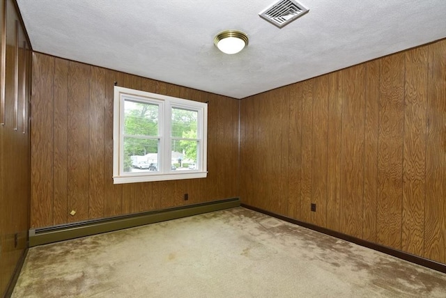 767 S Main St, Bellingham, MA 02019 - spare room with a baseboard heating unit, carpet flooring, wooden walls, and a textured ceiling