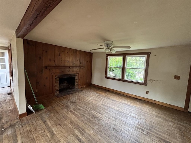 15 Reid Ave, Yarmouth, MA 02673 - unfurnished living room with a fireplace, wood finished floors, ceiling fan, wood walls, and baseboards