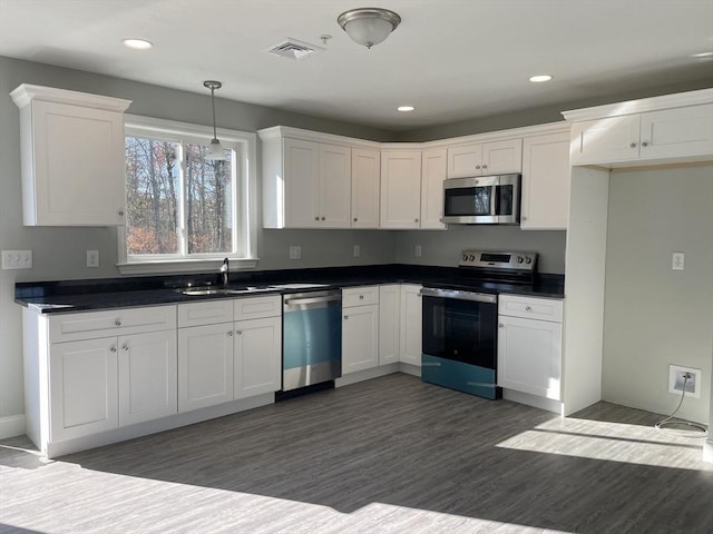 kitchen with pendant lighting, sink, dark hardwood / wood-style floors, white cabinetry, and stainless steel appliances