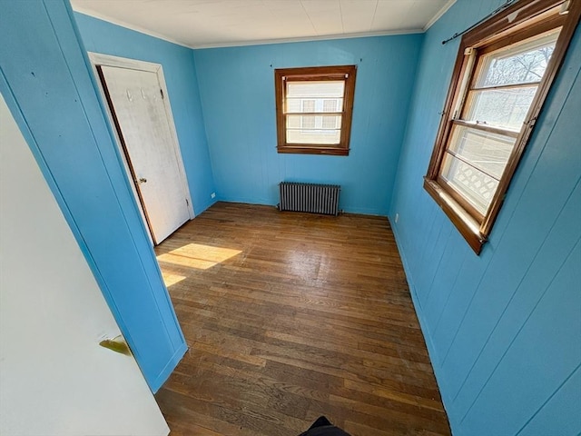 spare room featuring crown molding, radiator heating unit, and dark hardwood / wood-style floors