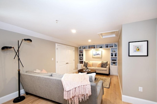 living area with attic access, baseboards, recessed lighting, and light wood-style flooring