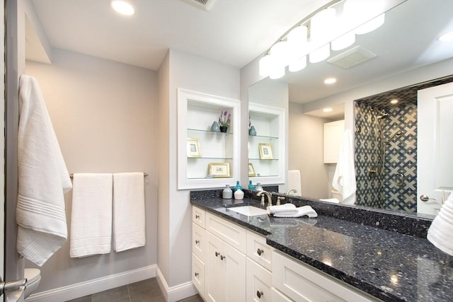 bathroom featuring tile patterned flooring, toilet, vanity, baseboards, and a shower