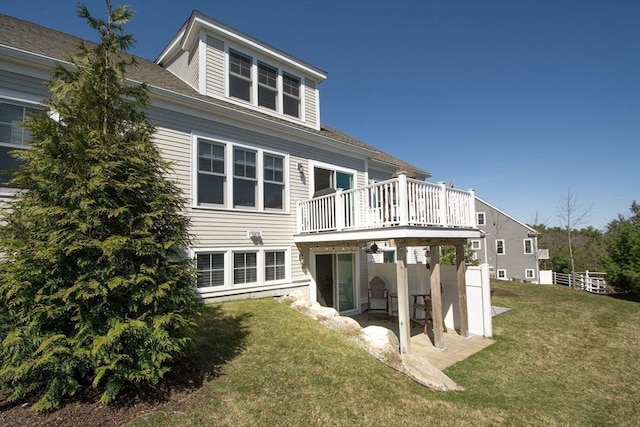 back of house featuring a wooden deck, a yard, and a patio
