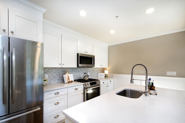 kitchen with a sink, white cabinetry, appliances with stainless steel finishes, and crown molding