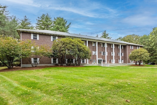 rear view of house featuring a lawn