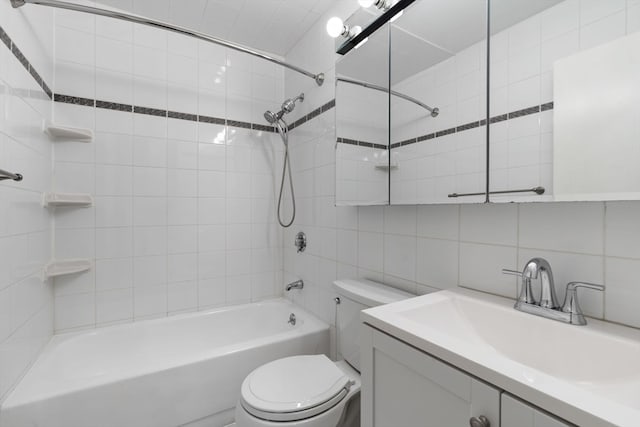 full bathroom featuring backsplash, vanity, tiled shower / bath combo, tile walls, and toilet