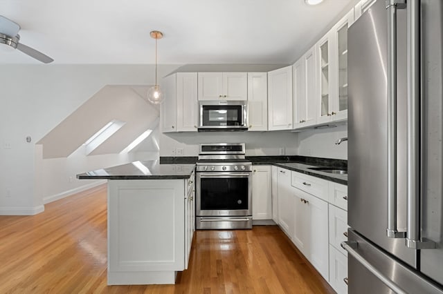 kitchen with white cabinets, pendant lighting, stainless steel appliances, and light hardwood / wood-style floors