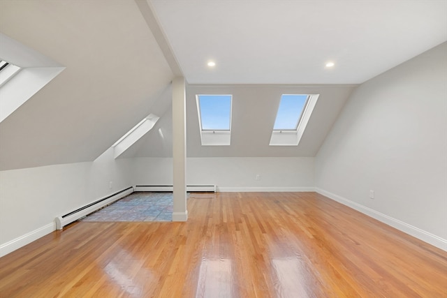 bonus room with vaulted ceiling with skylight, light wood-type flooring, and a baseboard radiator