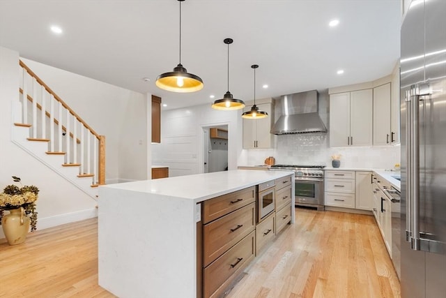 92 Cedar St, Lexington, MA 02421 - kitchen with wall chimney exhaust hood, high end appliances, light wood finished floors, light countertops, and a center island