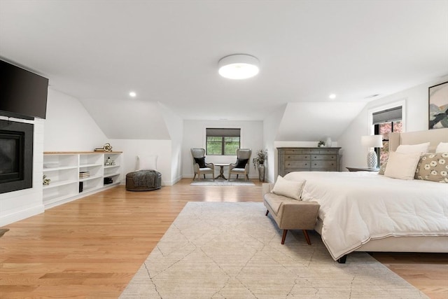 92 Cedar St, Lexington, MA 02421 - bedroom with vaulted ceiling, light wood-style flooring, a glass covered fireplace, and baseboards