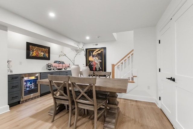 92 Cedar St, Lexington, MA 02421 - dining space featuring beverage cooler, a bar, light wood finished floors, stairway, and baseboards