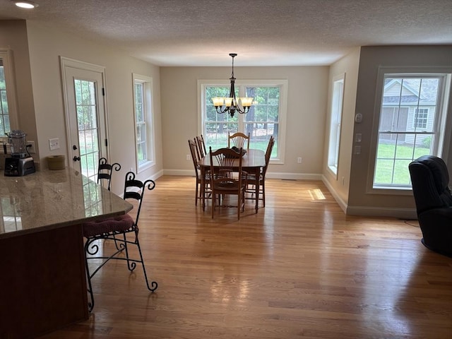 43 Caddyshack Dr, Chicopee, MA 01020 - dining room with light wood finished floors, a chandelier, and a textured ceiling